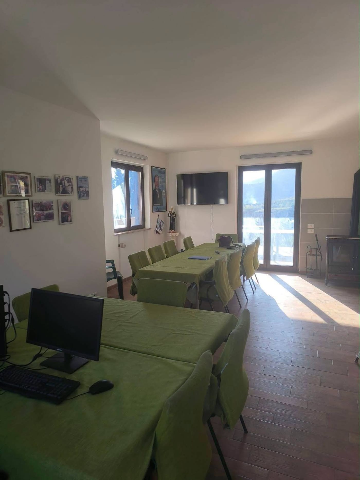 La sala interna della sede, con i tavoli, le postazioni e la vista sulle colline di Monreale