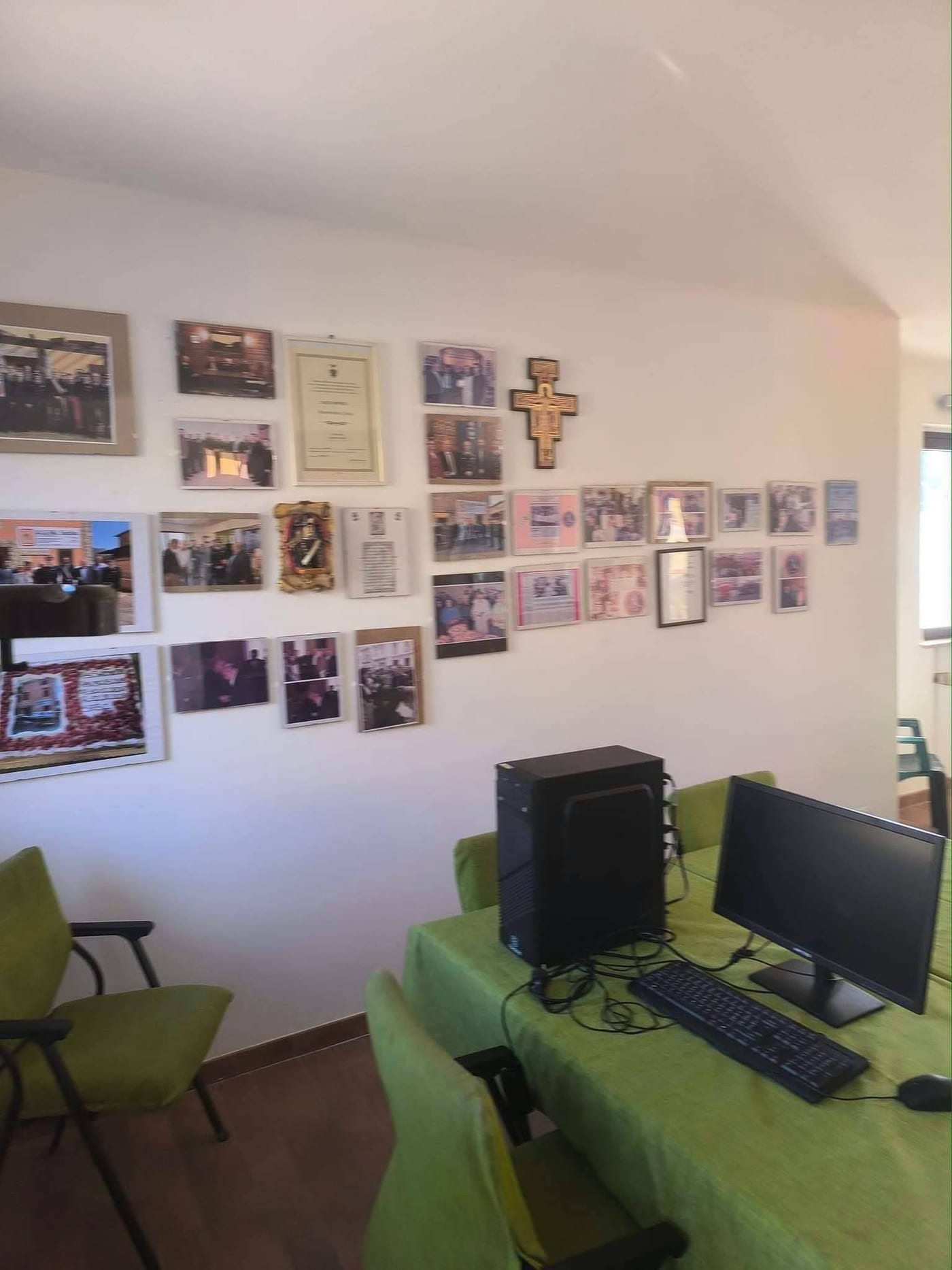 La parete della sede con le fotografie incorniciate, gli attestati e i ritagli di giornale di anni di attività