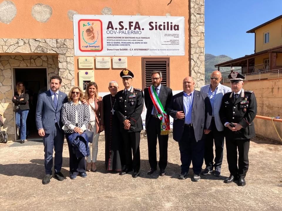 La facciata della sede con lo striscione dell'associazione, durante una cerimonia con autorità civili, militari e religiose